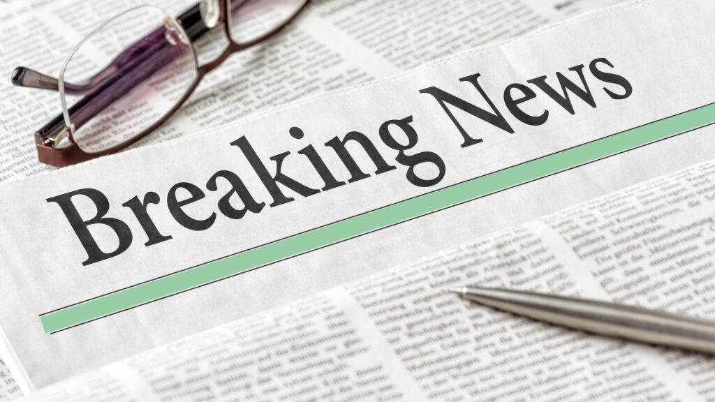 A newspaper shows a headline that reads "breaking news"